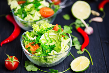 fresh vegetable and green seaweed salad in a glass plate
