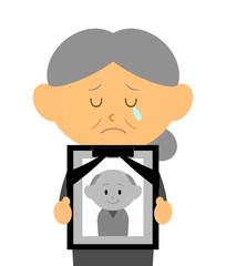 夫の遺影を持つ女性