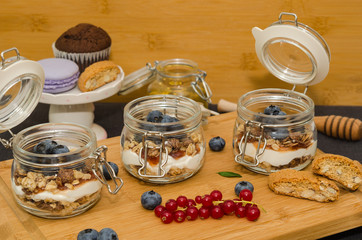 Blueberry parfaits in mason jars, on a wooden background. Healthy still life concept food. Yogurt...