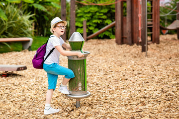 Blonde boy in the straw hat and big glasses and girl in white and blue dress in the entertainment park