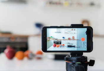 Phone camera on tripod in kitchen. Vlogging concept.