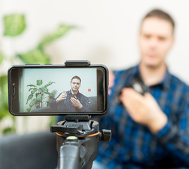 Man making video blog about photo camera lenses.