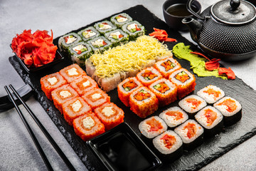 Big sushi set with variety of sushi rolls,on stylish dark background.