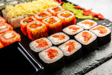 Big sushi set with variety of sushi rolls,on stylish dark background.