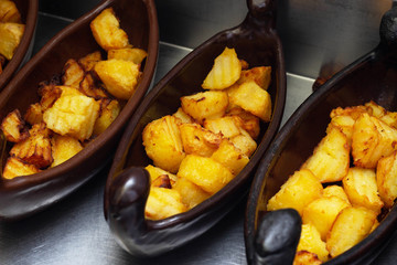 Restaurant dish of a boat with potatoes in a golden crust fried in a deep fryer. close-up