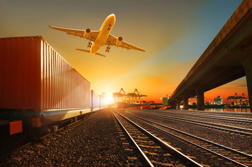 cargo plane flying over container trains and commercial shipyard background