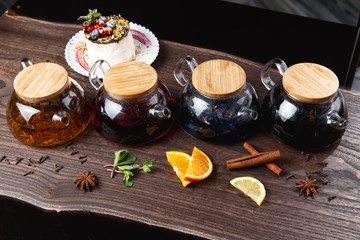 various teas in teapots on a wooden table. selective focus
