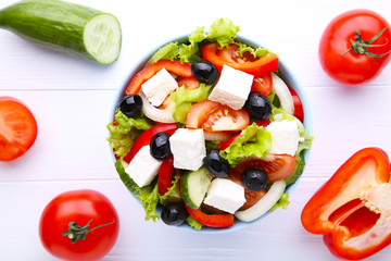 Fresh vegetable salad on bowl on white wooden background
