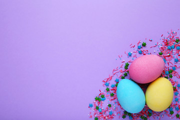 Colorful easter eggs with sprinkles on a pink background