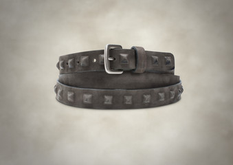 Brown suede leather belt with pyramids on beautiful background