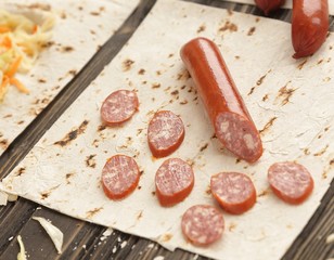 sausages, pickled cabbage and pita bread on wooden background