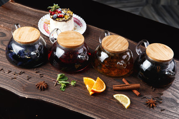 various teas in teapots on a wooden table. selective focus