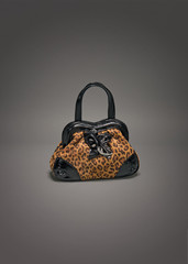 Small leather purse with leopard pattern on gradient gray background