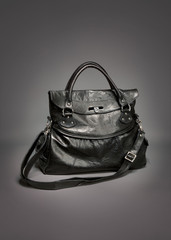 Black leather handbag on gradient gray background