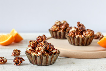 Chocolate popcorn in rustic baking molds on a wooden table