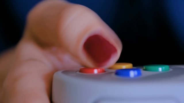 Close up shot of woman gamer hand playing video games with joystick or gamepad at home. Gaming, hobby, addiction, video game and leisure time concept