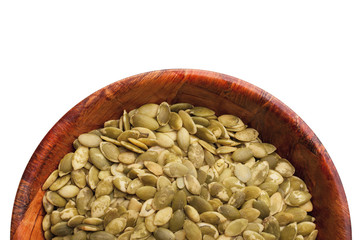 Raw green pumpkin seeds without shells inside wooden bowl. Empty copy space healthy diet food ingredient in round kitchen container studio background.