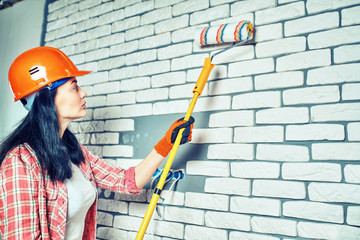 Girl builder in special clothes at the workplace.