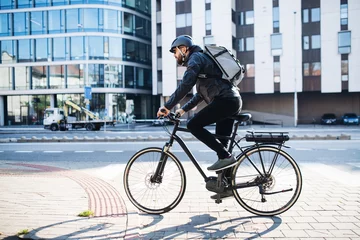 Foto op Plexiglas Male courier with bicycle delivering packages in city. Copy space. © Halfpoint