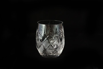 Vintage empty crystal glass on the black background.