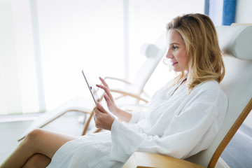 Beautiful woman relaxing and using tablet in spa