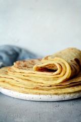 Norwegian potato pancakes Lefse on a light background with cheese and greens. Traditional Scandinavian cuisine.