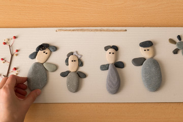 teach to make picture with stones. Mother,father,boy and girl which have been made with colorful stones.children handmade activity time in school.