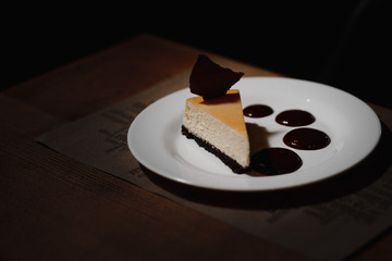 cheesecake on the plate under the light of the lamp