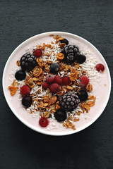 Healthy beautiful breakfast bowl with yogurt, granola and berries.