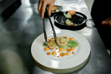the cook arranges the vegetables on the plate