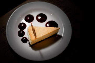 cheesecake on the plate under the light of the lamp