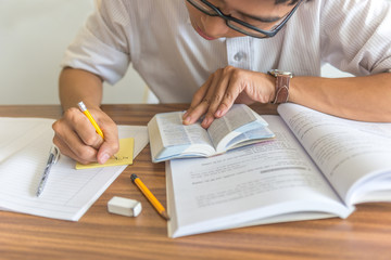 Young student read books and take note of information