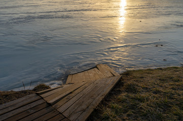 Boardwalk at the edge of a lake at sunset