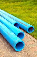Plastic water pipes on a stone walkway.
