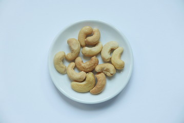 Top view of cashew nuts in bowl on white background.