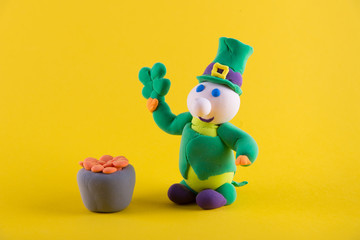 Saint Patrick day decorations. Toy lerpechaun on yellow background