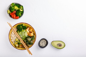 Buddha bowls on white background. Colorful bowls with vegetables, healthy grains, and protein. Rice, lentils, tofu, avocado, broccoli, brussels sprouts, bok choy, sesame seeds.  Top view. Copy space.