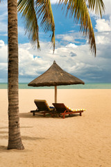 wo lonely loungers on the deserted beach of Hainan Island. 