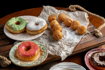 Cottage cheese balls and donutts on wooden skewers, lie on craft paper.