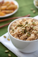 Oatmeal with pumpkin seeds in a white bowl. Healthy breakfast.