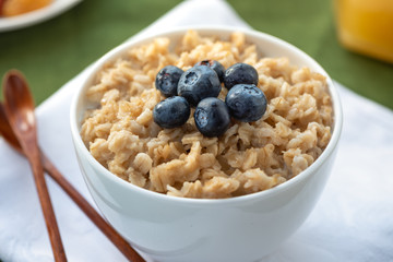 Oatmeal with blueberries in a white bowl. Healthy breakfast.