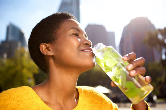 healthy young woman drinking water outdoors