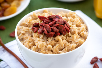 Oatmeal with goji berries in a white bowl. Healthy breakfast.