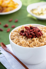 Oatmeal with goji berries in a white bowl. Healthy breakfast.