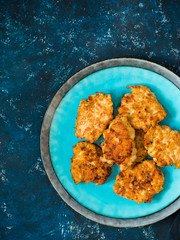 Homemade fried chicken cutlets, fillet nuggets in ceramic plate on dark blue background. Diet concept. Healthy food. Flat lay