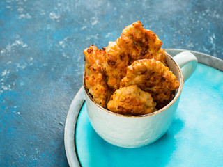 Homemade fried chicken cutlets, fillet nuggets in ceramic mug on blue background. Diet concept. Healthy food