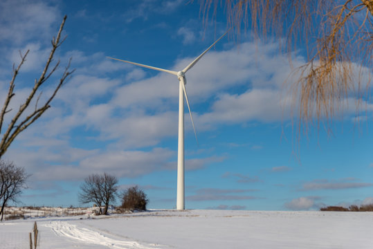 Grande éolienne dans un paysage en hiver avec de la neige sur fond de ciel bleu en Moselle