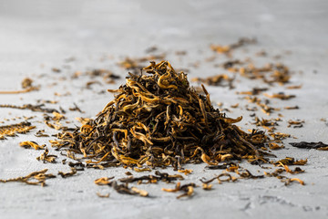 Red tea loose dried tea leaves,  on grey backrgound 