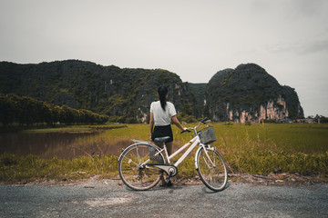 Obraz premium Woman with bicycle at countryside paddy field Vietnam