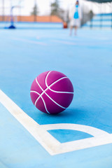 Boy practicing basketball sport on blue court and ball